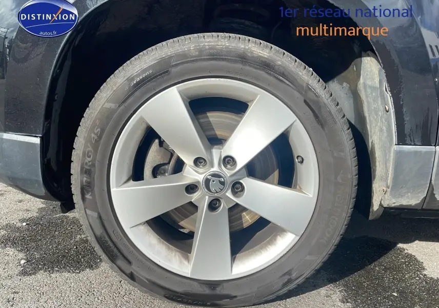 Gros plan sur la roue avant gauche en jante alu argentée d'un Skoda Karoq noir 2018.