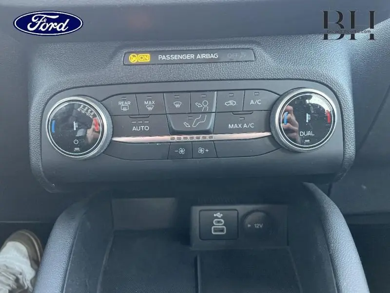 Vue rapprochée de la commande de climatisation bi-zone noire du Ford Kuga 2023 avec ports USB et prise 12V en dessous.