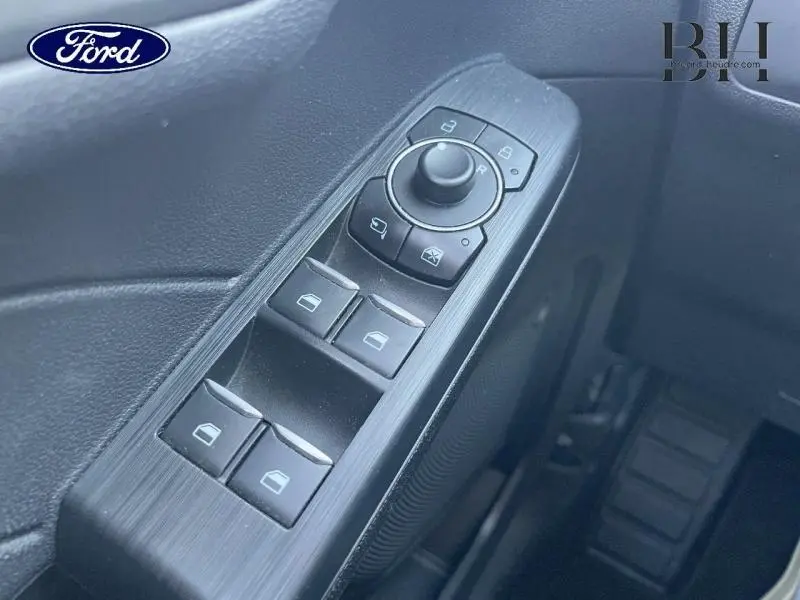 Gros plan sur les commandes de lève-vitres et rétroviseurs côté gauche d’un Ford Kuga 2023 bleu azur métallisé.