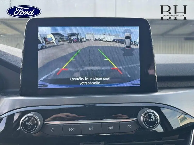 Écran tactile intérieur du Ford Kuga 2023 montrant la caméra de recul avec lignes de guidage colorées.