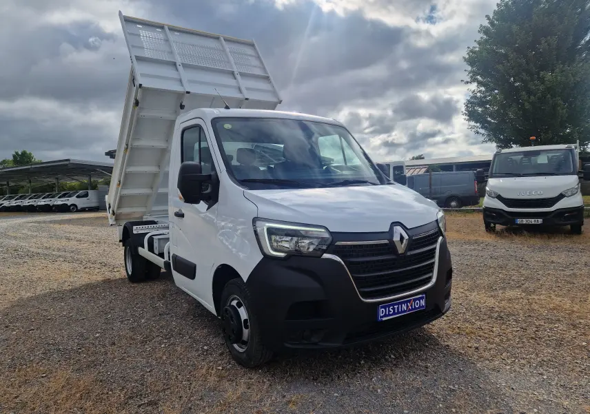 Renault Master Châssis cabine blanc vu en 3/4 avant droit avec benne relevée et roues jumelées visibles.