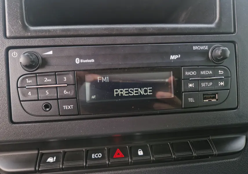 Gros plan sur la radio Bluetooth MP3 du tableau de bord noir du Renault Master Châssis Cabine blanc, version benne 2024.