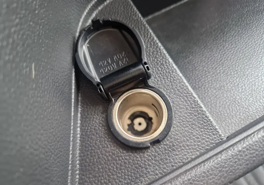 Prise 12V ouverte en gros plan sur la console intérieure noire du Renault Master Châssis Cabine blanc 2024.