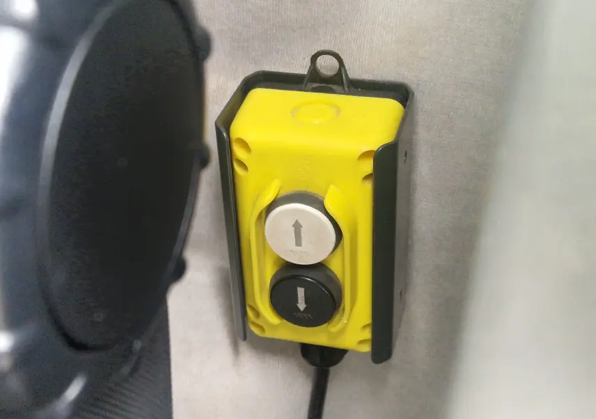 Bouton de commande jaune avec deux touches fléchées montée à l'intérieur du Renault Master Châssis Cabine blanc.