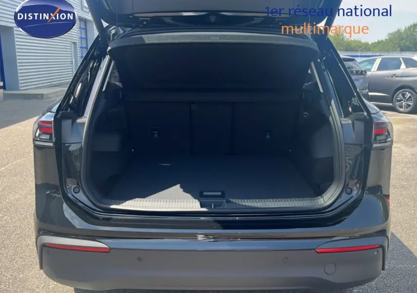 Vue arrière du Volkswagen Tiguan noir Grenadilla métallisé 2026 avec coffre ouvert et intérieur spacieux visible.