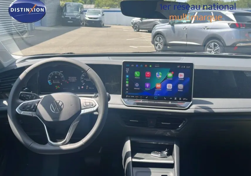 Vue intérieure du tableau de bord du Volkswagen Tiguan 2026, avec volant noir et écran tactile central lumineux.