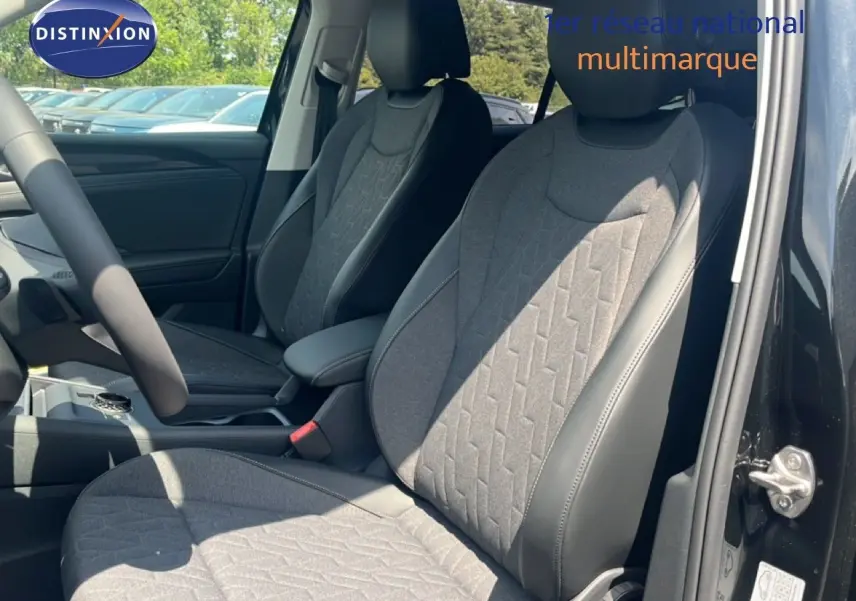 Vue intérieure côté conducteur du Volkswagen Tiguan 2026 noir Grenadilla, sièges tissu et cuir gris avec motifs géométriques.