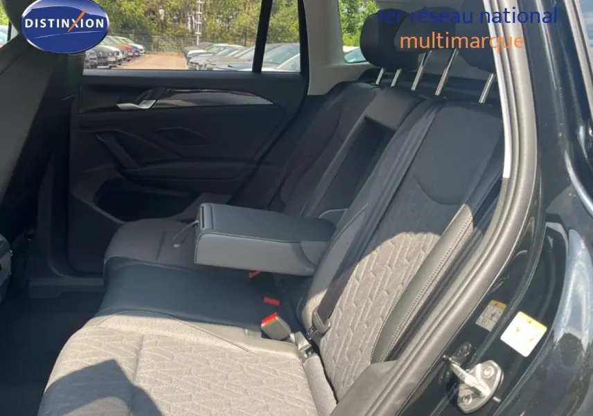 Vue intérieure côté droit des sièges arrière du Volkswagen Tiguan noir Grenadilla, avec accoudoir central déployé.
