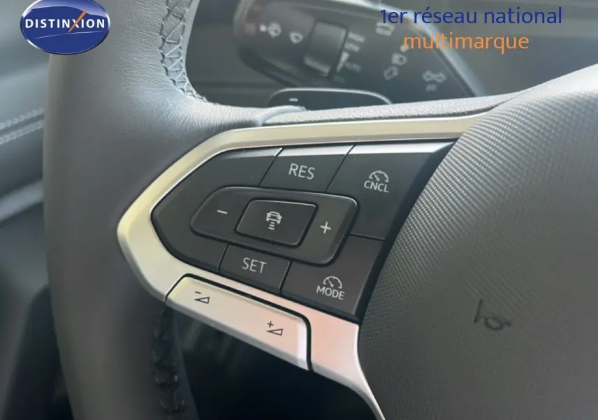 Gros plan sur les commandes au volant du Volkswagen Tiguan 2026, finition noire avec boutons de régulateur de vitesse.
