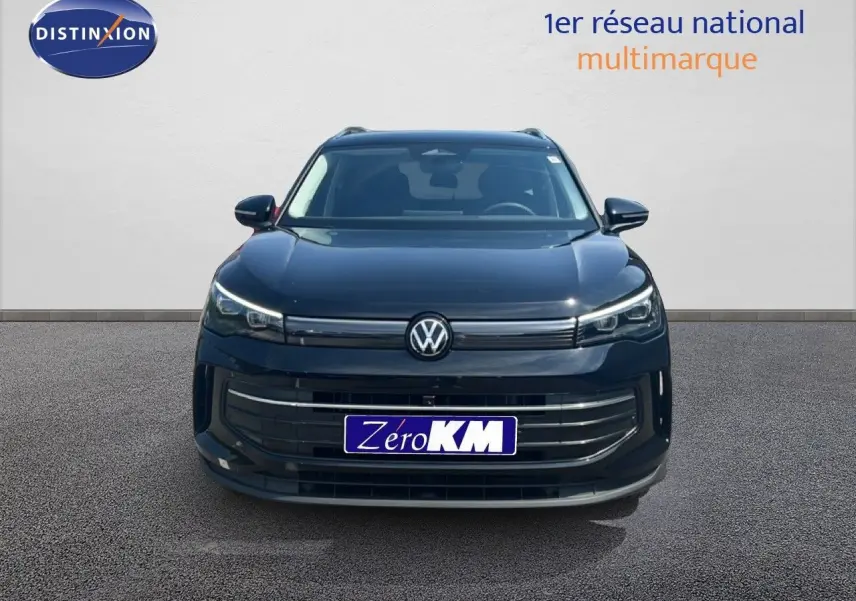 Vue frontale d'un Volkswagen Tiguan noir Grenadilla métallisé avec calandre et phares LED distinctifs.