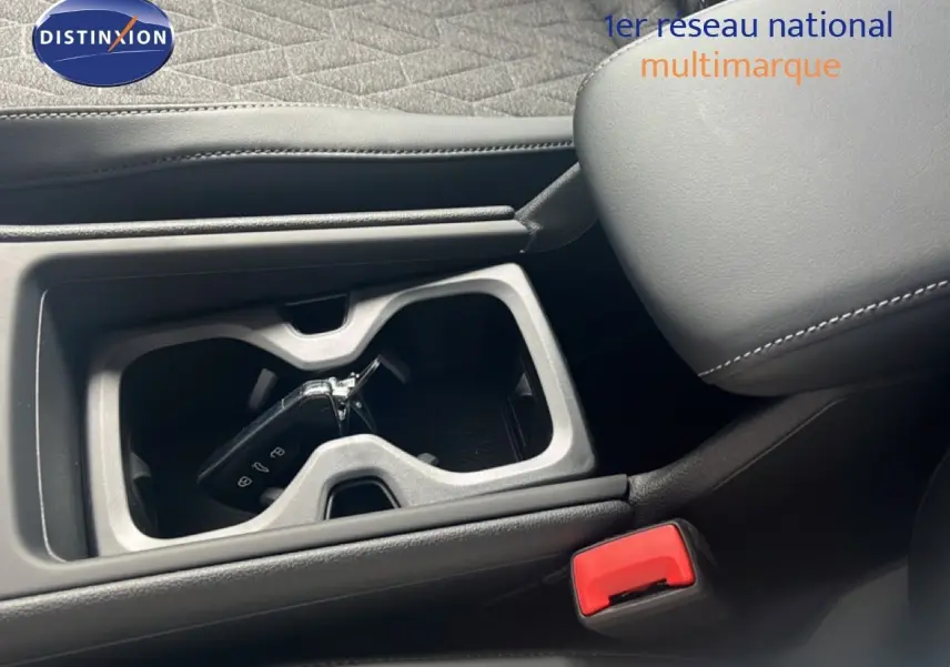 Gros plan intérieur sur la console centrale noire du Volkswagen Tiguan 2026 avec clé dans porte-gobelets et accoudoir cuir.