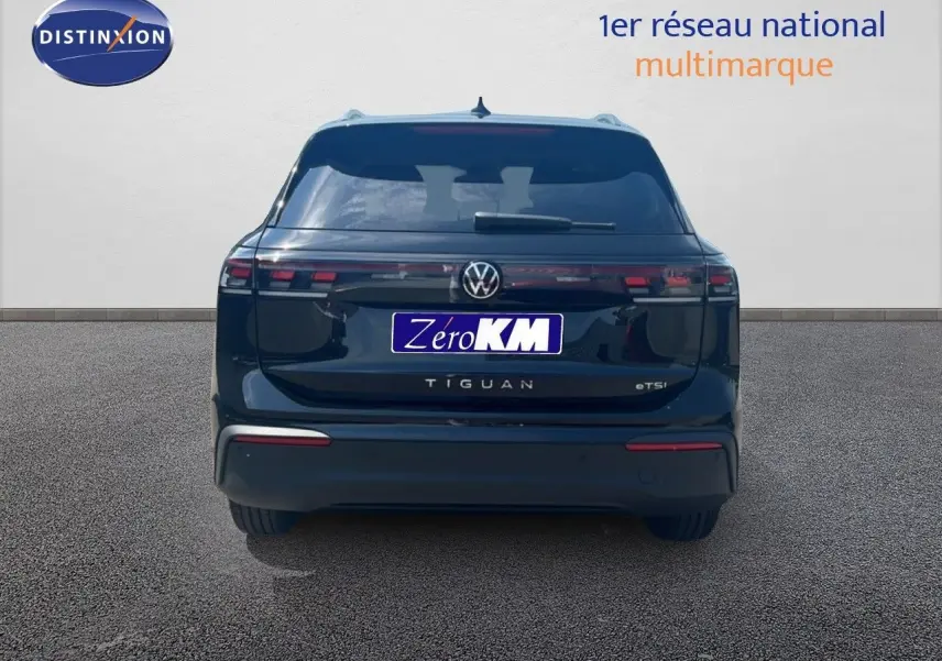 Vue arrière d'un Volkswagen Tiguan noir Grenadilla Metal 2026 avec feux LED et logo central visible.