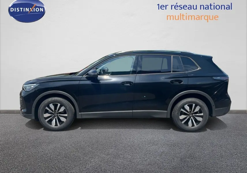 Profil droit du Volkswagen Tiguan noir Grenadilla métallisé, finition 30 Years, sur fond clair neutre.