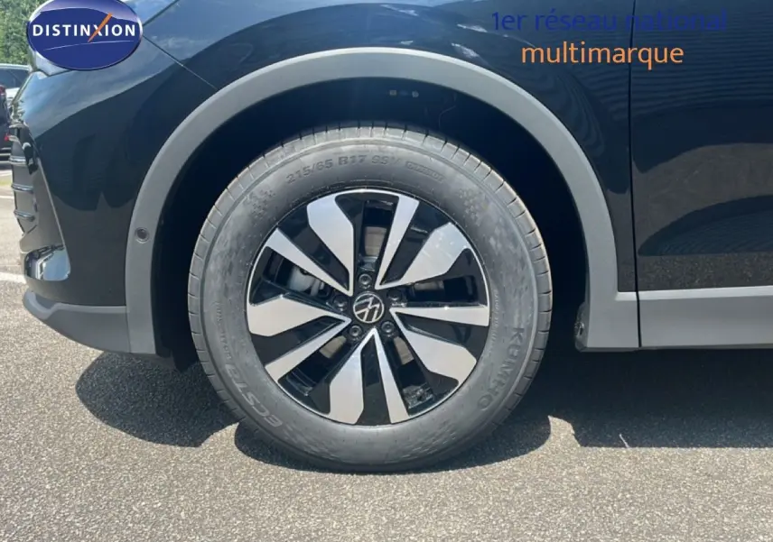 Gros plan sur la roue avant gauche du Volkswagen Tiguan noir Grenadilla 2026 avec jante alliage bicolore distinctive.