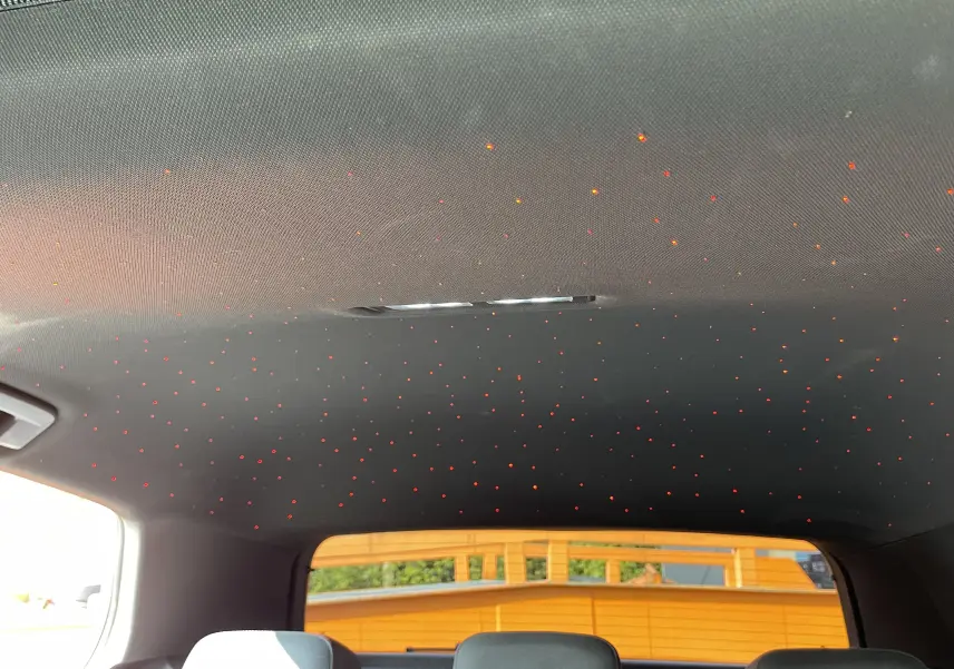 Toit intérieur noir de la Volkswagen Golf VIII GTI 2021 avec éclairage d'ambiance en points lumineux rouges.