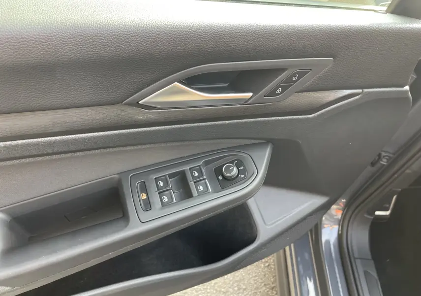 Panneau de porte côté conducteur gris foncé de la Volkswagen Golf VIII GTI 2021 avec commandes des vitres et serrure.