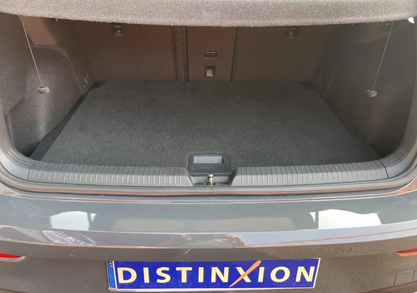 Coffre ouvert d'une Volkswagen Golf VIII GTI gris, vue arrière mettant en valeur l'espace de chargement vide.