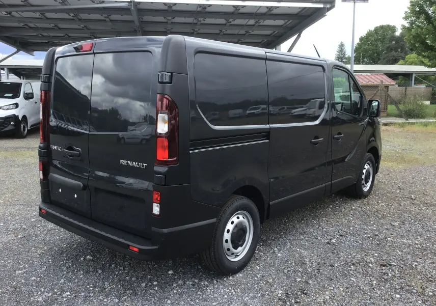 Vue 3/4 arrière droite d’un Renault Trafic Fourgon gris comète 2025, avec portes arrière fermées et jantes acier.