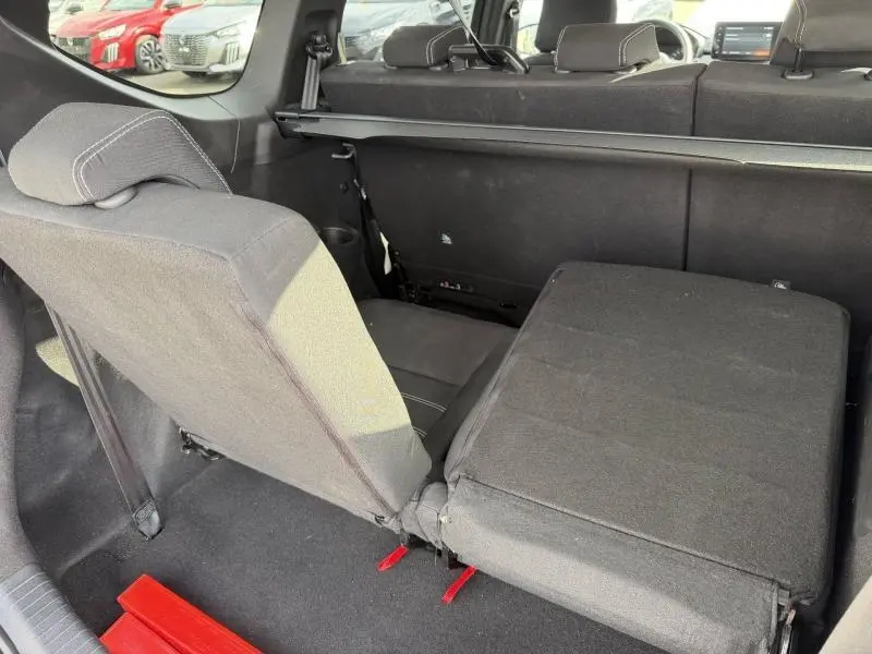 Vue intérieure arrière du Dacia Jogger 2025 montrant la banquette 7 places avec siège rabattable en tissu noir.