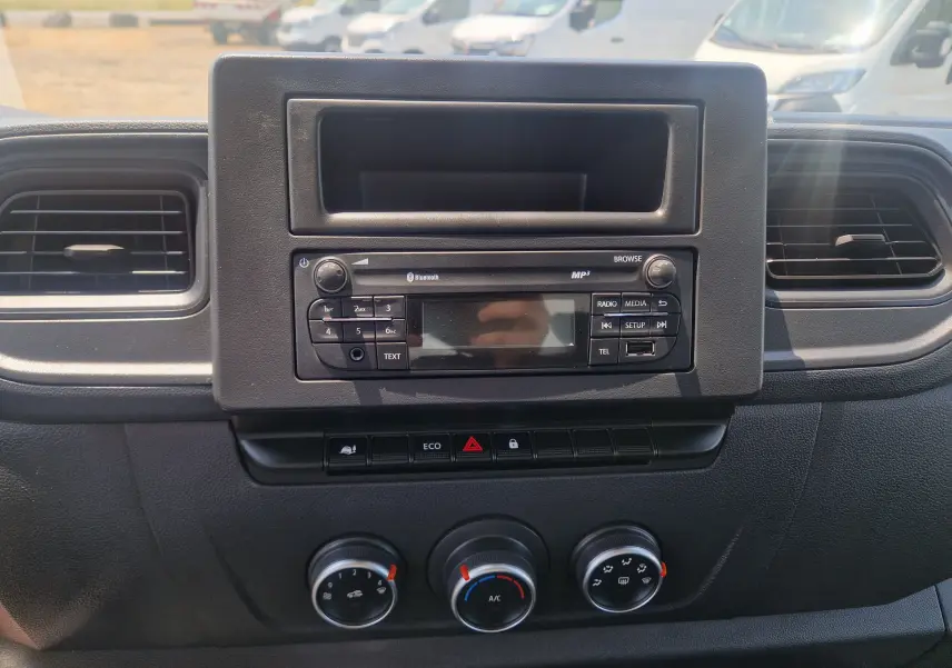 Tableau de bord noir du Renault Master Châssis Cabine 2024, vue frontale centrée sur la radio et les commandes de climatisation.