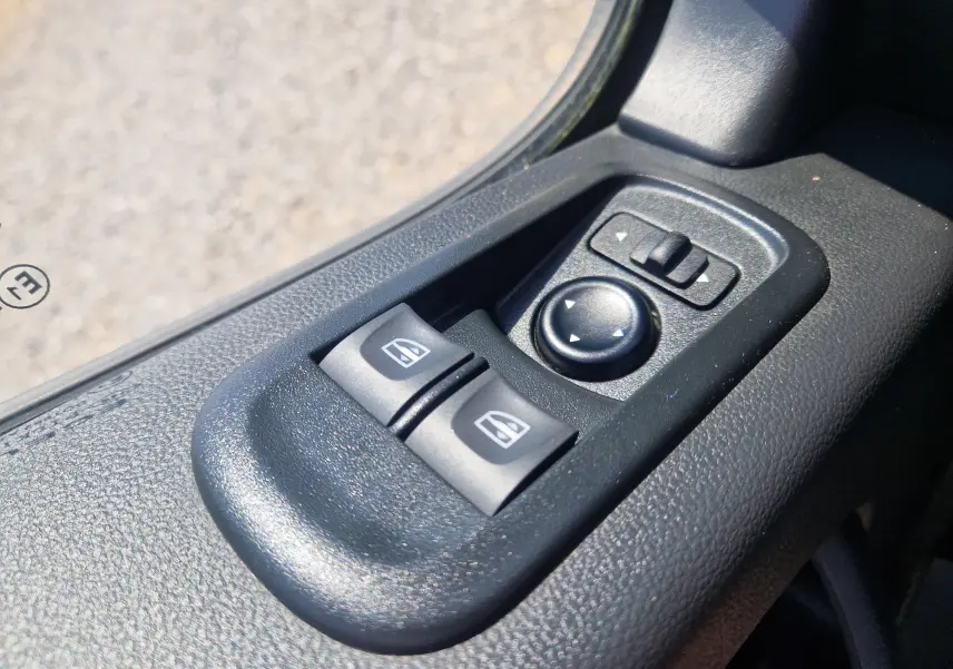 Gros plan sur les commandes de réglage des vitres et des rétroviseurs électriques côté conducteur du Renault Master Châssis Cabine blanc.