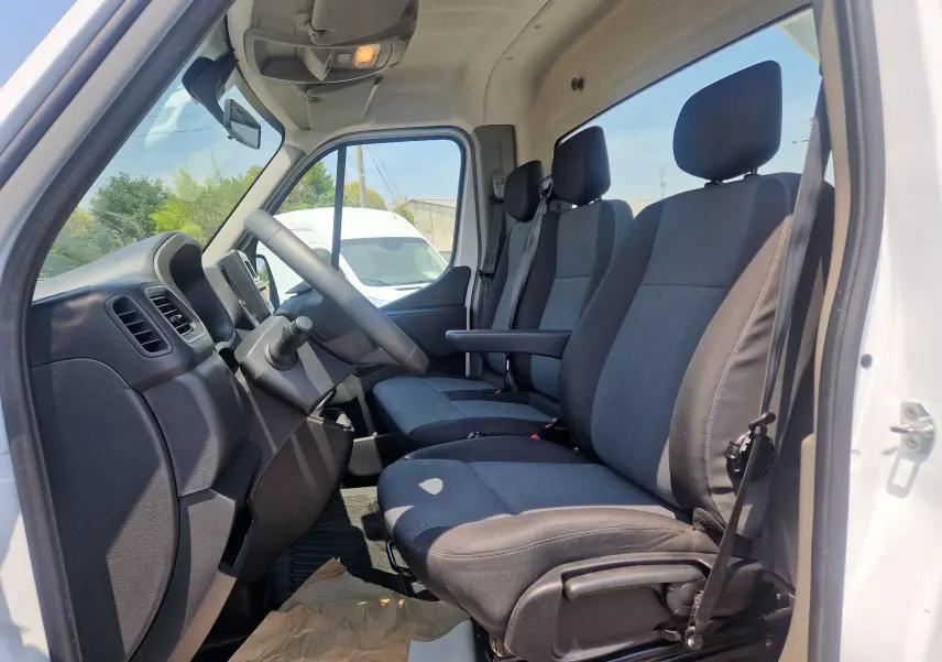 Vue intérieure côté conducteur du Renault Master Châssis Cabine blanc 2024, montrant les sièges gris et le tableau de bord.