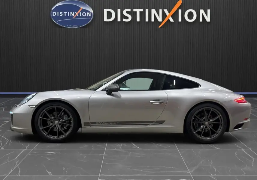 Profil droit d'une Porsche 911 991.2 Carrera T gris GT Silver avec jantes Carrera S noires et logo latéral distinctif.
