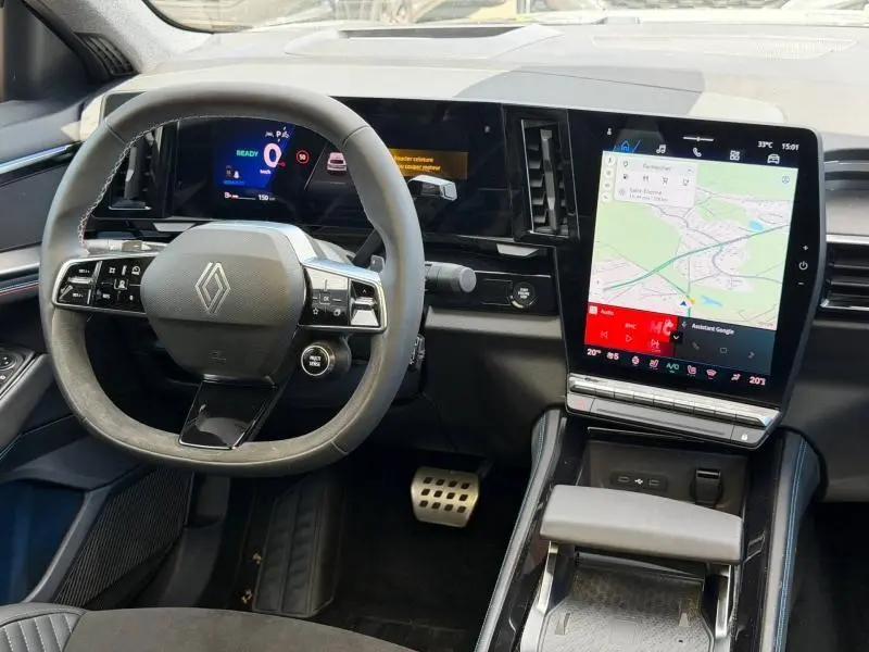 Vue intérieure avant du tableau de bord et volant multifonction du Renault Rafale 1.2 E-Tech hybride avec écran tactile vertical.