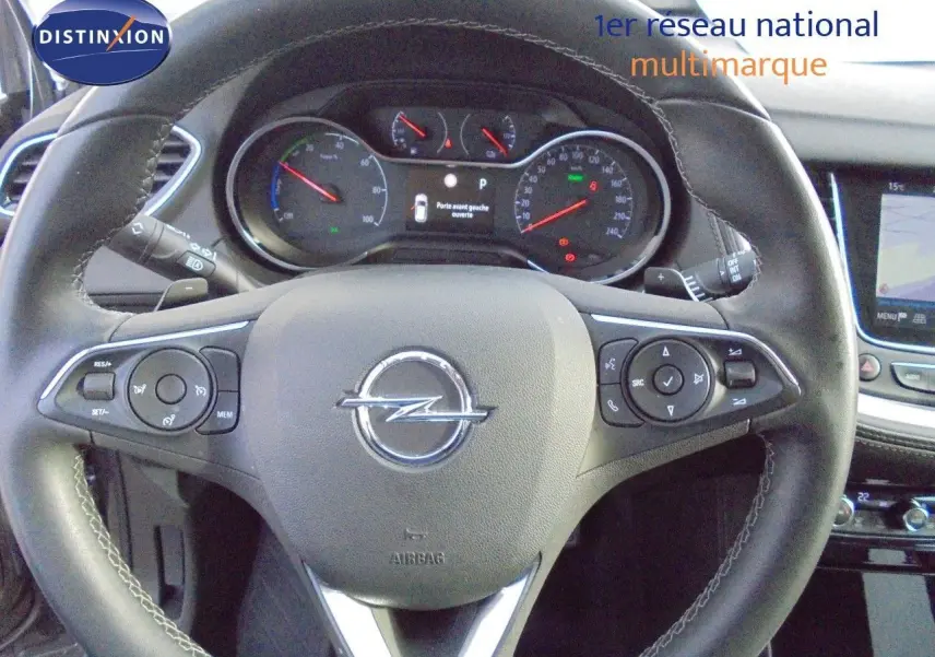 Vue intérieure centrée sur le volant cuir noir et le tableau de bord avec écran tactile du Opel Grandland X gris Moai Metal 2021.