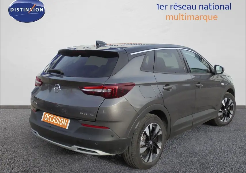 Opel Grandland X gris Moai Metal vu en 3/4 arrière droit, soulignant ses feux LED et jantes alliage noires.