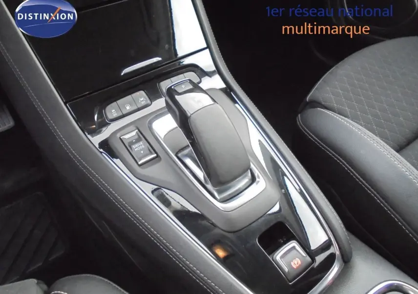 Le levier de vitesses automatique et les commandes de mode de conduite dans l'habitacle noir de l'Opel Grandland X hybride.