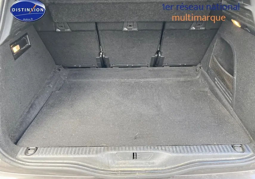 Coffre ouvert du Citroën C4 Picasso gris 2016, montrant un espace de chargement propre et tapis noir.