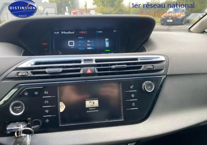 Tableau de bord et écran tactile central du Citroën C4 Picasso gris, avec affichage de l'aide au stationnement.