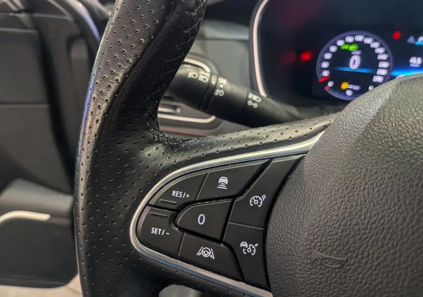 Gros plan sur le volant en cuir noir de la Renault Talisman Estate 2022, avec commandes de régulateur de vitesse visibles.