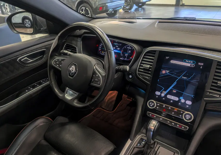 Vue intérieure côté conducteur de la Renault Talisman Estate 2022, tableau de bord noir avec écran tactile et volant cuir.