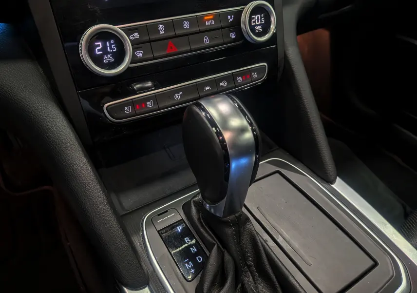 Le levier de vitesse automatique de la Renault Talisman Estate 2022 en cuir noir, avec commandes de climatisation et sièges chauffants visibles.