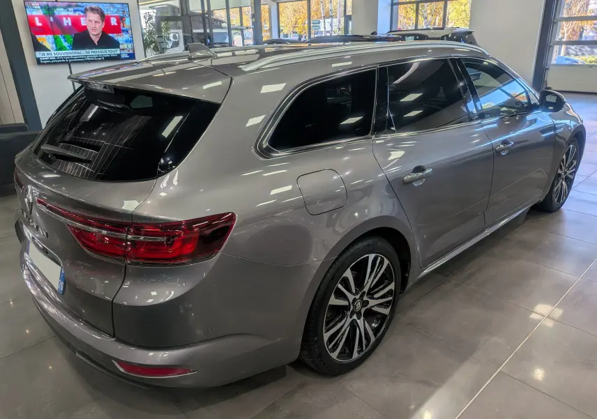 Renault Talisman Estate gris Cassiopé vue 3/4 arrière droit en intérieur avec jantes bi-ton et vitres teintées.