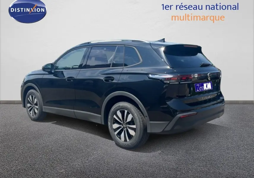 Volkswagen Tiguan noir grenadilla métal vu en 3/4 arrière droit, avec jantes alliage et toit ouvrant.