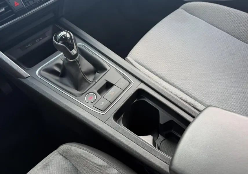 Vue rapprochée de la console centrale de la SEAT LEON ST 1.5 TSI 115 Style avec levier de vitesse manuel et sellerie textile grise.