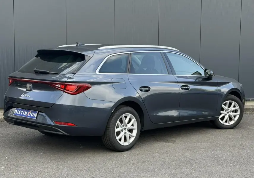 SEAT Leon ST gris magnétique vue 3/4 arrière droit, jantes alliage 16 pouces et vitres arrière surteintées.