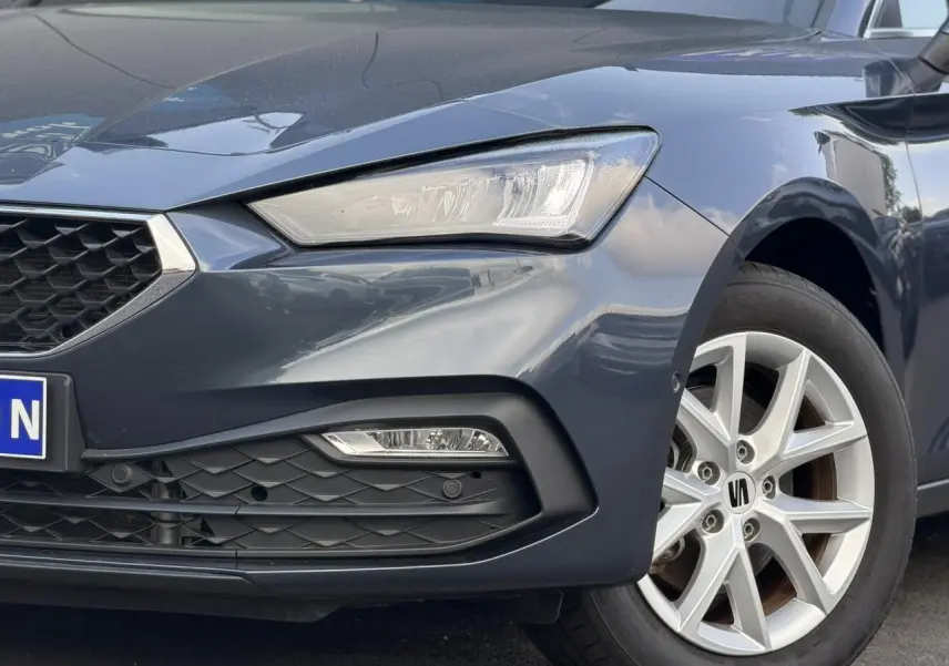 Gros plan sur l'avant droit gris magnétique du SEAT LEON ST 2025, mettant en valeur le phare LED et la jante alliage 16 pouces.