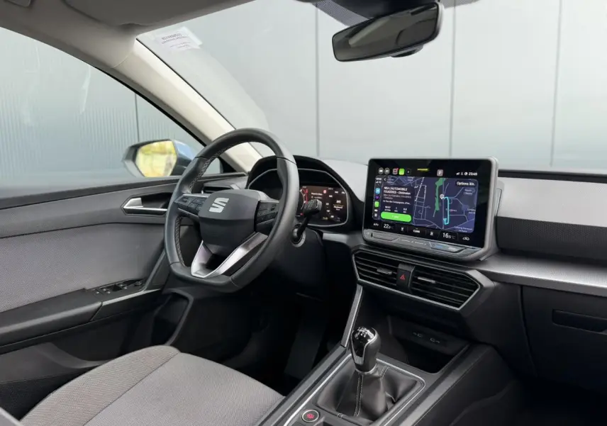 Vue intérieure côté conducteur du SEAT Leon ST 2025, montrant le volant cuir multifonction et l’écran tactile 10,4 pouces.