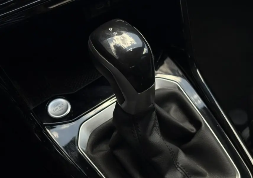 Gros plan sur le levier de vitesses automatique noir brillant du Volkswagen T-Roc 1.5 TSI R-Line 2025 avec bouton start/stop.