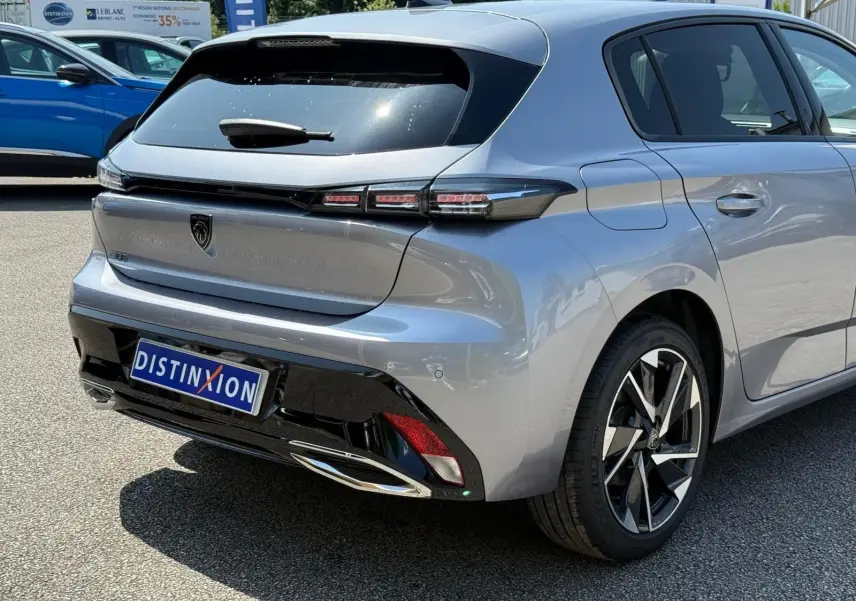 Vue 3/4 arrière droite d'une Peugeot 308 gris Artense avec feux LED et jantes alliage distinctives.