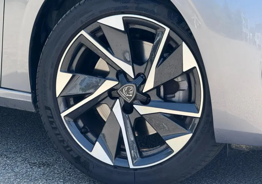 Gros plan sur la jante avant droite de la Peugeot 308 gris Artense avec un design moderne bicolore.