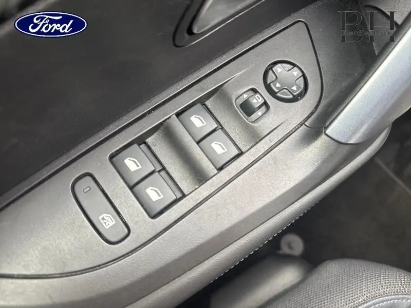 Panneau de commandes des vitres et rétroviseurs côté conducteur, intérieur noir, plastique mat et tissu gris.