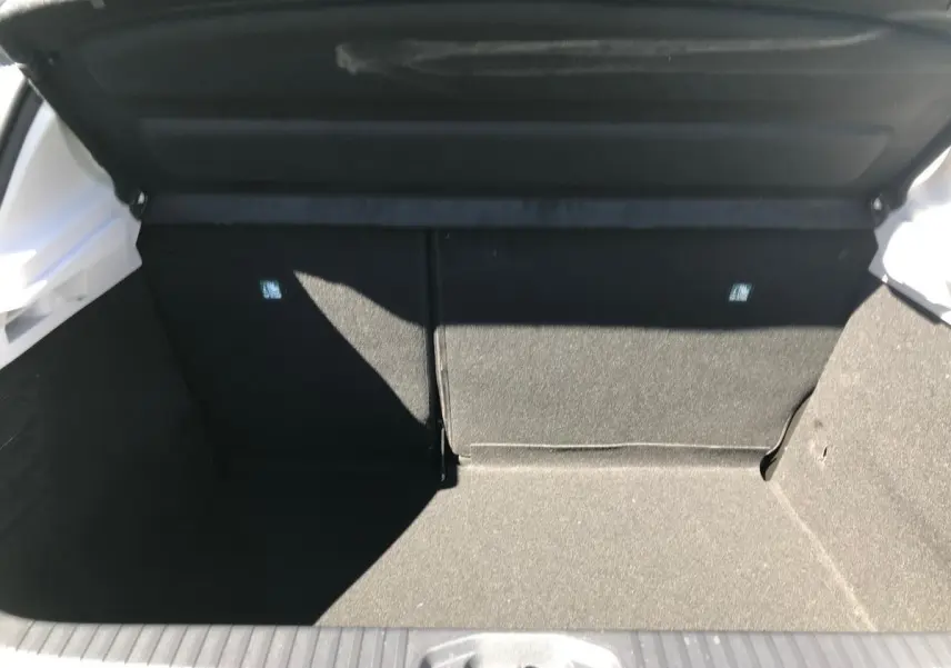 Coffre ouvert d'une Renault Clio Gris Urban 2021, vue intérieure montrant l'espace de chargement et banquette rabattable.