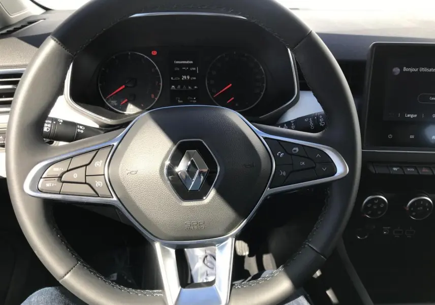 Volant TEP multifonctions Renault Clio 2021 vu de face, avec tableau de bord et écran tactile en arrière-plan.
