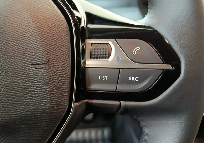 Gros plan sur les commandes multifonctions à droite du volant en cuir noir du Peugeot 208 PureTech 100 S&S Allure.