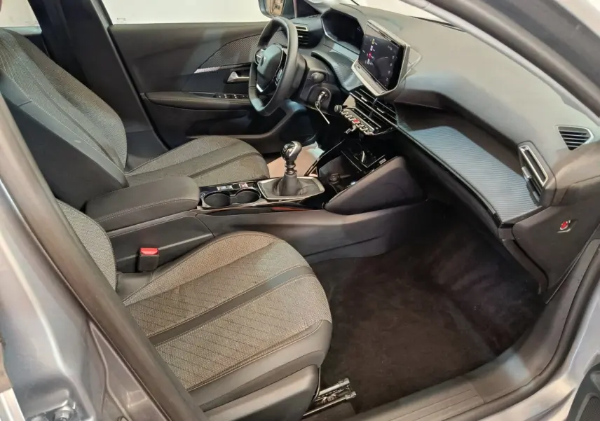 Vue intérieure côté conducteur de la Peugeot 208 PureTech 100 S&S Allure avec tableau de bord moderne et écran tactile.